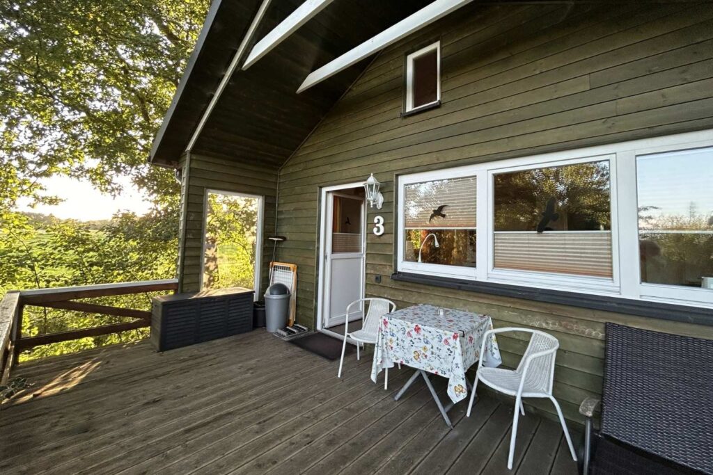Ferienhaus Waldhaus auf dem Ferienhof Ohlenbusch mit überdachter Holzterrasse, Sitzmöbeln und eigenem Eingang